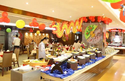 a buffet line with people preparing food in a restaurant at FARS Hotel & Resorts - BAR-Buffet-Pool-SPA in Dhaka
