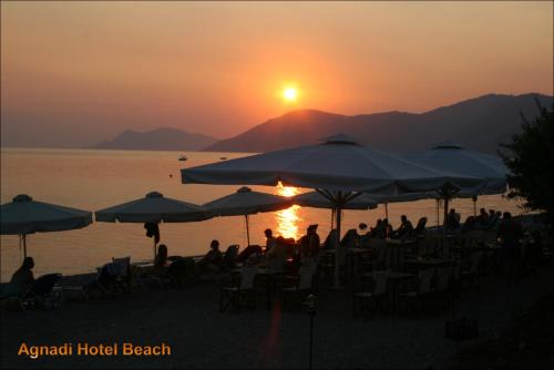 people sitting on the beach watching the sunset at Agnadi Hotel in Rovies