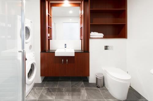 a bathroom with a sink and a toilet and a mirror at Abode Narrabundah in Canberra