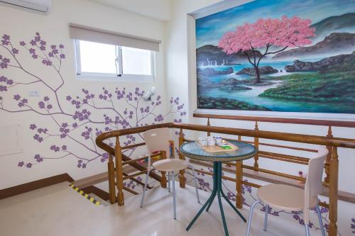 a room with a painting on the wall and a table at Hsieh's Home in Taitung City