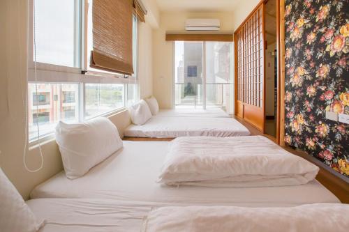 2 Betten in einem Zimmer mit Fenster in der Unterkunft Hsieh's Home in Taitung