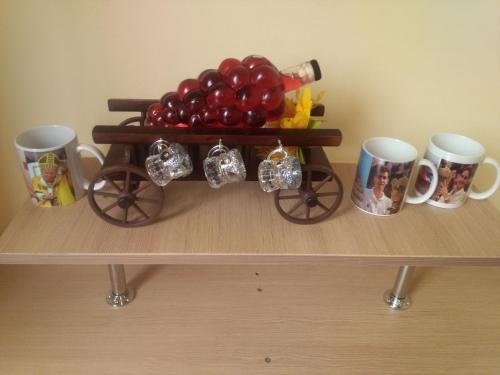 a table with a tray of tomatoes and mugs at Casa Ovi și Simo in Haţeg