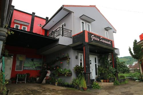 a white and red building with a sign on it at Green Savanah Homestay Syariah in Diyeng