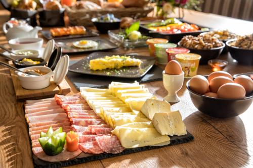 ギュッシングにあるHotel der Freiraumのチーズ、肉、卵を盛り付けたテーブル