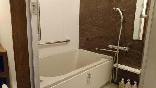 eine weiße Badewanne im Bad mit Dusche in der Unterkunft Hotel Taiheiyo in Matsushige