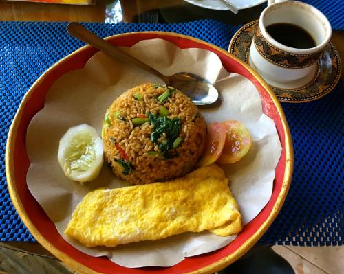 een bord met eten, een gebakken ei en een muffin bij Bulian Homestay in Kubutambahan