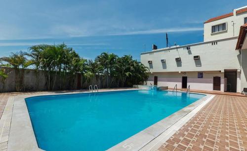 a large blue swimming pool in front of a building at Seagate Church View Resorts in Velānganni