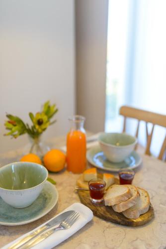 a table with plates and bowls of food and oranges at Dona Graca Lisbon Apartments in Lisbon