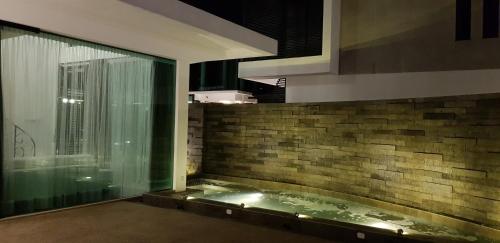 a bath tub in a room with a large window at Hermitage Boutique House in Taiping