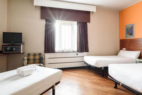 a hotel room with two beds and a tv at Crisol Quindós in León