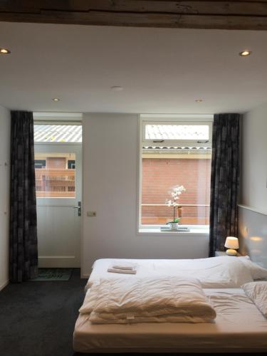 - une chambre avec un grand lit et une fenêtre dans l'établissement Appartementen Rijnhoeve, à Koudekerk aan den Rijn