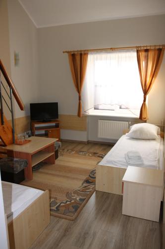 a bedroom with a large bed and a window at Dom Litewski in Sejny