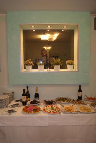 a table with plates of food and bottles of wine at Residence Aprilia in Grado
