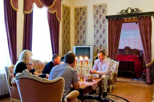 a group of people sitting around a table with candles at Cantervilla Castle in Otepää