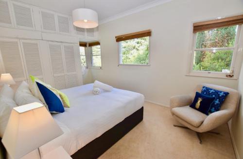 1 dormitorio con 1 cama y 1 silla en Calamandah House of Blackheath, en Blackheath