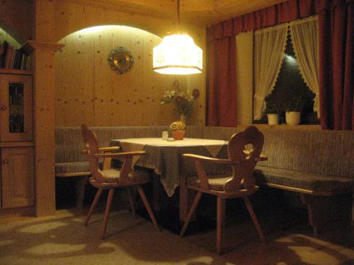 a dining room with a table and chairs and a chandelier at ban Kneissl`s in Umhausen