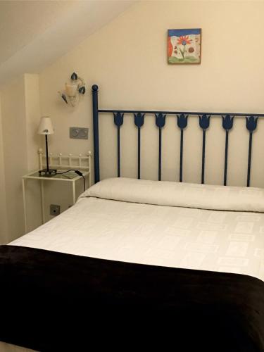a bedroom with a bed with a blue head board at Apartamentos Costa Noja in Noja