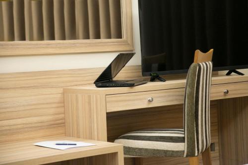 a laptop sitting on a desk next to a television at Bzommar Palace Hotel in Harisa
