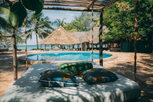 a bed with turtles on it next to a swimming pool at Mikadi Beach Camp & Backpackers in Dar es Salaam