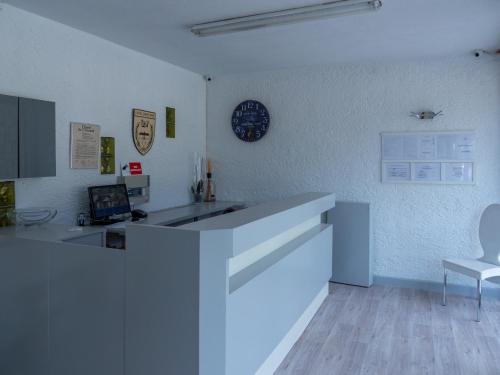 a kitchen with a counter and a clock on the wall at Hôtel Castel Saint Anne in Le Castellet