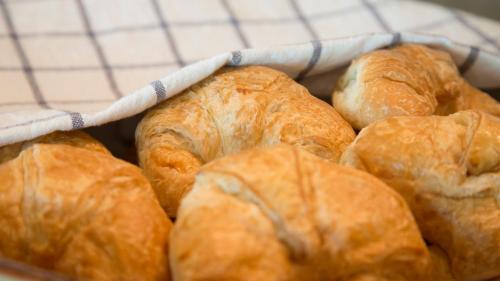 einen Korb voller Croissants auf einem Tisch in der Unterkunft The Mantrini Chiang Rai in Chiang Rai