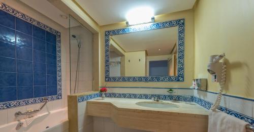 ein Bad mit einem Waschbecken und einem Spiegel in der Unterkunft Regency Hotel & Spa in Monastir