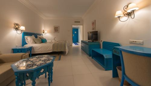 a blue bedroom with a bed and a couch at Regency Hotel & Spa in Monastir
