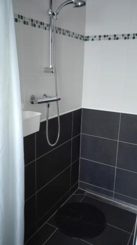 a bathroom with a shower with a black and white tiles at Ferienwohnung Belle Vue in Bernkastel-Kues