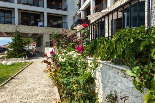 a retaining wall with flowers in front of a building at Regina Maria Spa Design Hotel in Balchik
