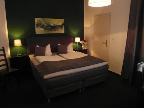 a bedroom with a large bed with green walls at Hotel Frankfurter Hof in Limburg an der Lahn