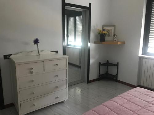 een slaapkamer met een dressoir, een spiegel en een deur bij Casa Tiziana in Napels