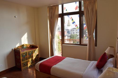 a bedroom with a bed and a large window at ROKPA Guest House in Kathmandu