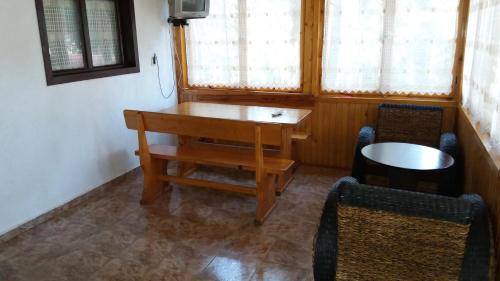 a room with a wooden table and two chairs at Ваканционно селище Ива in Sarnitsa