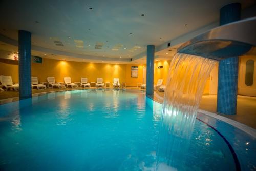 uma piscina com cascata num quarto de hotel em Hotel Colosseo & Spa em Shkodër