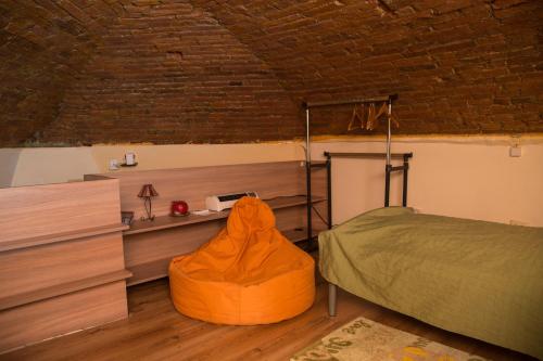 1 dormitorio con 1 cama con manta naranja en Downtown Studio, en Oradea
