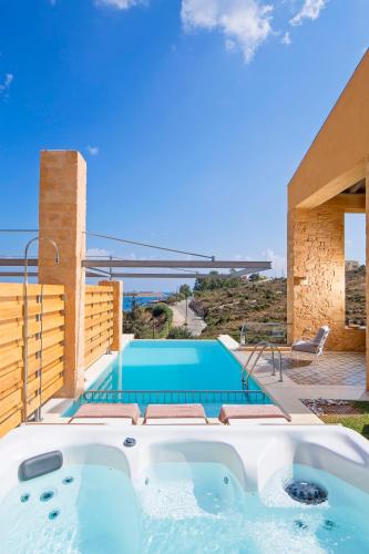 a villa with a swimming pool and a house at Olea Villas - Infinity Pool, Hot Tub, Sea Views in Marathi