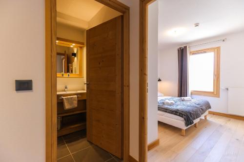 a bathroom with a bed and a sink in a room at TERRESENS - Les Fermes du Mont-Blanc in Combloux