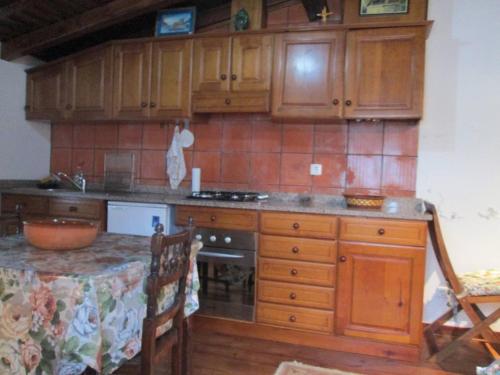 cocina con armarios de madera y encimera en Casinha à beira ribeirio, en Manteigas