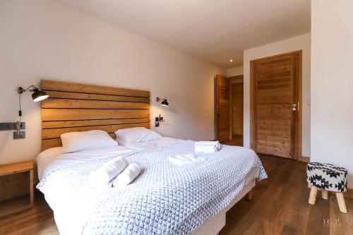 a bedroom with a large white bed with towels on it at TERRESENS - Les Fermes du Mont-Blanc in Combloux
