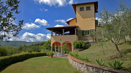 a house on a hill with a stone wall at Podere La Casina in Poppi