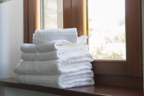 a stack of towels sitting on a shelf next to a window at Bed and breakfast Aratro & Rosmarino in Civitanova Marche