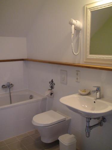 a bathroom with a sink and a toilet and a bath tub at Landhaus Ribbeck in Ribbeck