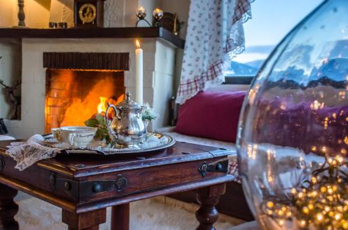 a table with a tea pot and a fireplace at Country guesthouse Αερικό in Karpenision