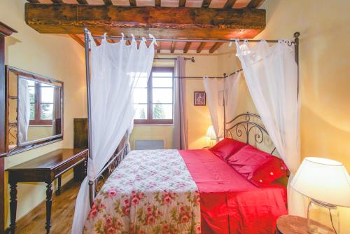 a bedroom with a red bed and a window at Ville Degli Ulivi in Laiatico