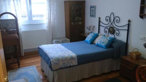 a bedroom with a bed with blue sheets and blue pillows at Villarei in Ribadeo