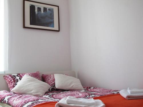 a room with a bed with pillows and a picture on the wall at Villa Marina in Augustów