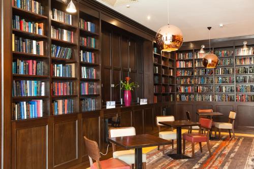 a book shelf filled with books on top of a wooden floor at Clayton Hotel, Leeds in Leeds