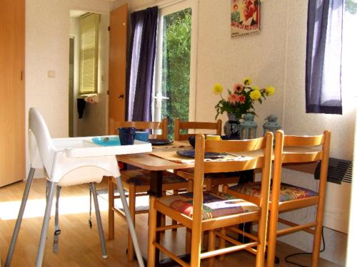 uma mesa de jantar e cadeiras num quarto em Stacaravan 6 persoons - Camping Le Soustran em Neuvic