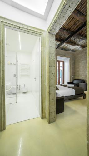 a bedroom with a bed and a bathroom with a shower at Chiaia 197 Deluxe Residence in Naples