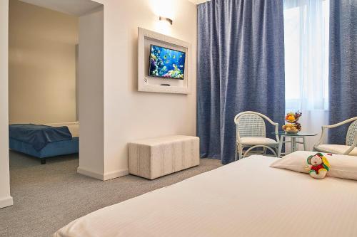 a hotel room with a bed and a television at Continental Forum Sibiu in Sibiu